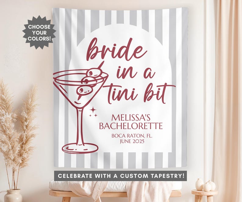 May include: A gray and white striped tapestry with the text "bride in a tini bit" in maroon. The text "Melissa's Bachelorette" is also in maroon, along with the location and date "Boca Raton, FL. June 2025". The tapestry also features a martini glass with olives in it.