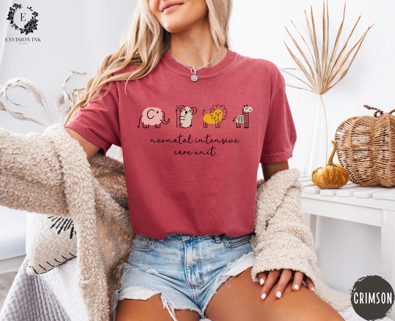May include: A red t-shirt with a graphic of a series of animals, including an elephant, a bear, a lion, and a giraffe. The text "neonatal intensive care unit" is printed below the animals.