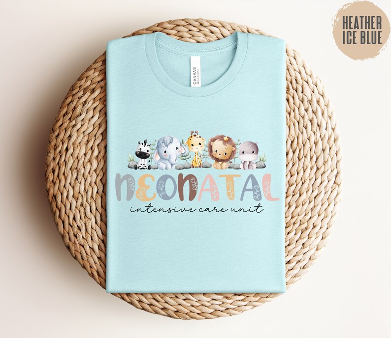May include: Light blue t-shirt with a graphic of a zebra, elephant, giraffe, lion, and hippopotamus. The text "Neonatal Intensive Care Unit" is printed below the animals.