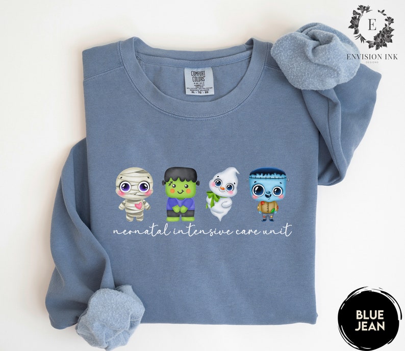May include: A blue sweatshirt featuring a graphic of four cute Halloween characters and the text "neonatal intensive care unit".