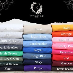 May include: A color chart of 18 different t-shirt colors, including white, ash, sport gray, dark heather, Irish green, military green, forest green, black, sand, light blue, Carolina blue, royal, indigo blue, navy, purple, gold, orange, light pink, safety pink, heliconia, red, maroon, and dark chocolate.