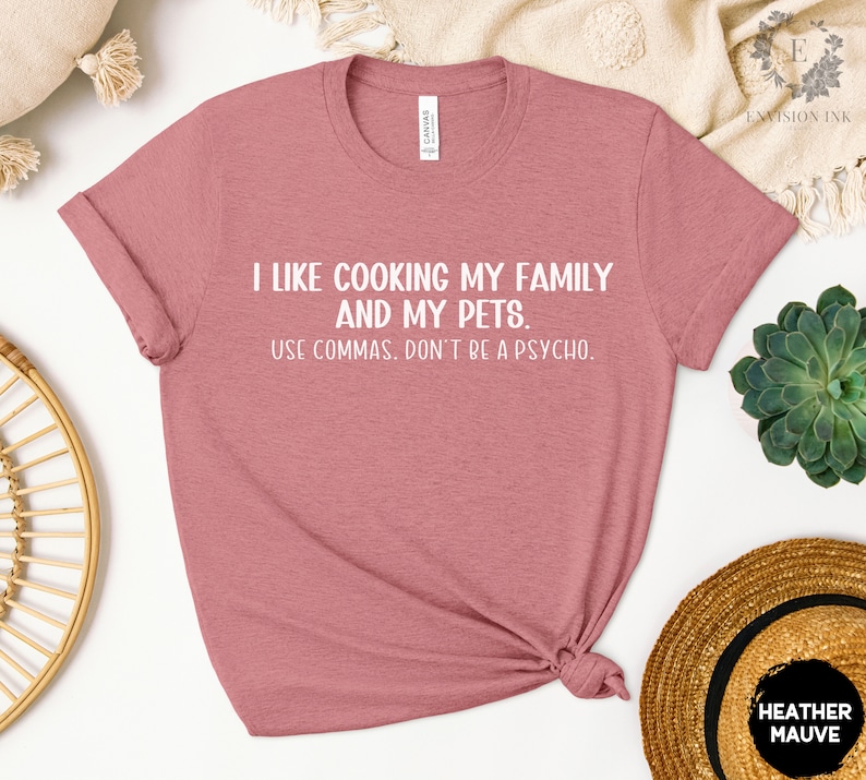 May include: A heather mauve t-shirt with white text that reads "I like cooking my family and my pets. Use commas. Don't be a psycho."