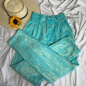 Op de afbeelding: Een high-waisted jeans in lichtblauw met een wit tie-dye patroon. De jeans heeft een relaxte pasvorm en een rechte pijp.