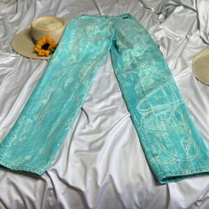 Op de afbeelding: Een lichtblauwe jeans met een wit tie-dye patroon. De jeans heeft een ontspannen pasvorm en een rechte pijp.