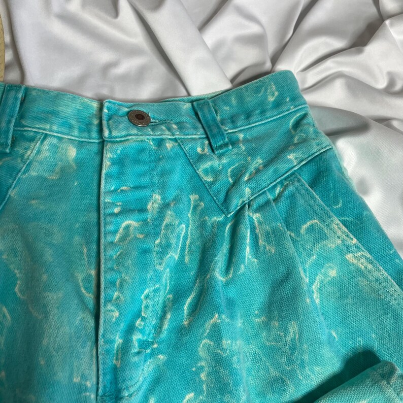 Op de afbeelding: Hoge taille denim shorts in lichtblauw met een wit marmerpatroon.