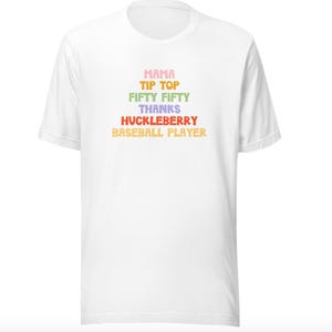 Puede incluir: Camiseta blanca con un gr&aacute;fico colorido que dice "Mama Tip Top Fifty Fifty Thanks Huckleberry Baseball Player".