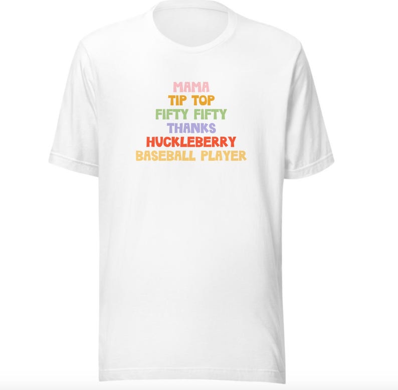 Puede incluir: Camiseta blanca con un gr&aacute;fico colorido que dice "Mama Tip Top Fifty Fifty Thanks Huckleberry Baseball Player".