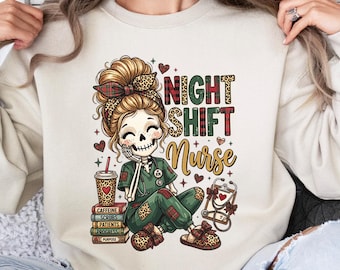 Könnte beinhalten: Ein beigefarbenes Sweatshirt mit Rundhalsausschnitt und einer Grafik eines Skelett-Krankenpflegers mit Dutt, in grüner Arbeitskleidung mit Leopardenmuster-Details. Der Text lautet NIGHT SHIFT Nurse, ergänzt durch Kaffeebecher, Bücher und Stethoskop.