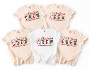 Könnte beinhalten: Fünf kurzärmelige T-Shirts mit Rundhalsausschnitt in Creme und Weiß. Jedes Shirt zeigt den roten und grünen Schriftzug "Christmas CREW" und "MAKING MEMORIES TOGETHER" mit kleinen grafischen Abbildungen von Tannen und Schneeflocken.