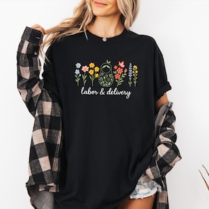 May include: Black t-shirt with a floral design and the text "labor & delivery".