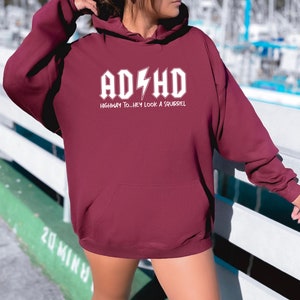 May include: Burgundy hooded sweatshirt with white text that reads "AD/HD HIGHWAY TO...HEY LOOK A SQUIRREL"