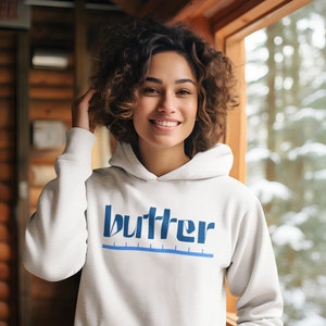 May include: A white hoodie with a blue graphic that says "butter" with a blue line underneath.