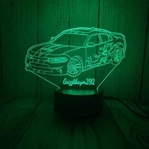 May include: A green 3D printed night light shaped like a Dodge Charger car with the name "Grizzlbayer392" printed on the base.