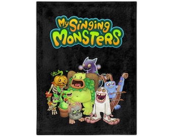 Può includere: Una coperta in pile nera con una grafica colorata del logo di My Singing Monsters e un gruppo di mostri dei cartoni animati. I mostri sono verdi, blu, viola e arancioni.