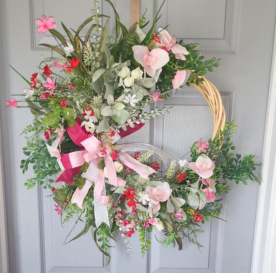 Wicker Wreath with multiple shades of pink and fuchsia flowers and greenery