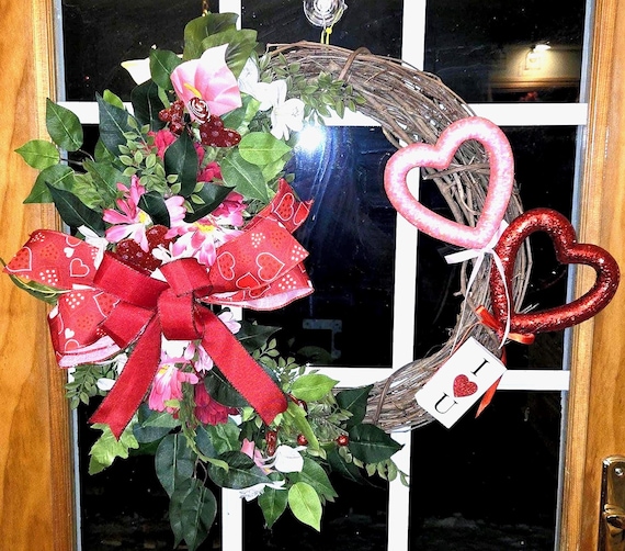 Valentine Grapevine Wreath done in the classic holiday colors of red and pink faux florals along with lush faux greenery