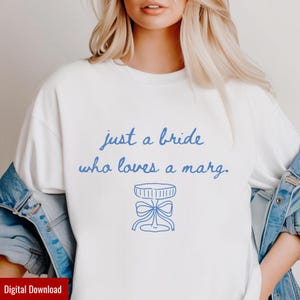 May include: White t-shirt with blue text that reads "just a bride who loves a marg." Below the text is a blue illustration of a margarita glass. The shirt is a digital download.