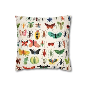 May include: Square throw pillow with a cream background featuring a colorful pattern of various insects, including butterflies, beetles, and ants. The insects are in shades of red, green, yellow, blue, and black.