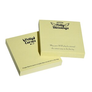 May include: Two yellow sticky note pads with black text. The top pad says "Petty Blessings" with a halo and wings. The bottom pad says "Petty Curses" with devil horns and a tail. The bottom pad also has the text "May your USB plug be oriented the correct way on the first try" and "I hope there's more crumbs than cereal left in the bag."