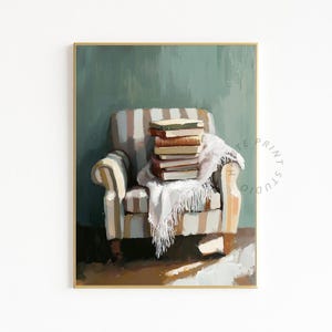 May include: An oil painting of a striped armchair with a stack of books and a white blanket. The artwork is framed in gold and set against a muted green background, evoking a cozy, literary theme.