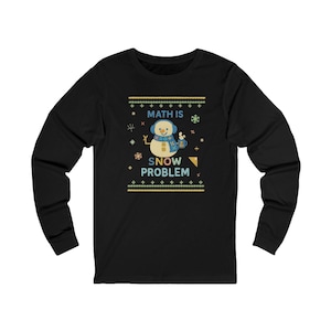 May include: Black long-sleeve shirt with a snowman graphic and the text "MATH IS SNOW PROBLEM". The snowman has a blue scarf and earmuffs. The design includes snowflakes and geometric shapes.