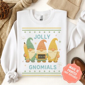 May include: White sweatshirt with a colorful graphic of three gnomes holding a pencil, a chalkboard with "x*x+4", and a ruler. The text "JOLLY GNOMIALS" is above and below the gnomes. The image is printed on the sweatshirt.