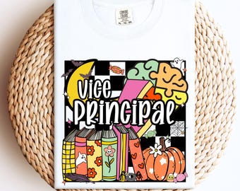 May include: White t-shirt with a colorful graphic design featuring the words "Vice Principal" in a playful font. The design includes a pumpkin, books, and Halloween-themed elements. The shirt is a Comfort Colors brand.