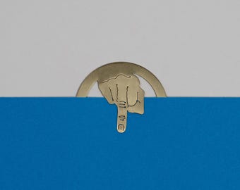 Może przedstawiać: Złoty zakładka w kształcie dłoni z wskazującym palcem. Zakładka znajduje się na niebieskim tle.