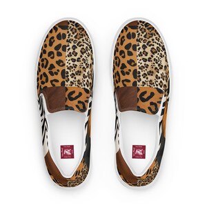 Könnte beinhalten: Ein Paar weiße Canvas-Slipper mit einem Patchwork-Design aus Leopard-, Zebra- und braunen Tierdrucken. Die Schuhe haben eine weiße Sohle und ein rotes Logo auf der Innensohle.