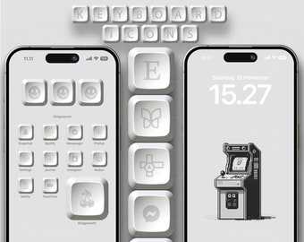 May include: A white iPhone with a custom home screen featuring white keyboard icons for various apps. The icons are arranged in a grid pattern and include apps like Snapchat, Spotify, Messenger, Photos, Settings, Journal, Instagram, Notion, Netflix, FaceTime, and Widgetsmith. The phone also has a white keyboard icon with a butterfly design and a white keyboard icon with a compass design. The phone is on a white background.