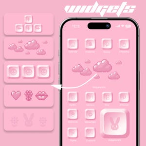 May include: A pink and white phone screen with a pink background and white icons. The icons are arranged in a grid and include apps like Calendar, Snapchat, Disney, Shopping, Netflix, Camera, Etsy, Pinterest, Shortcuts, Messenger, Figma, Contacts, and Widgetsmith. The phone screen also includes a pink cloud icon and a pink bunny icon.