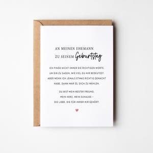 May include: A white greeting card with German text and a pink heart, inside a brown envelope. The card's text is a birthday message to a husband. The card is a romantic gift.