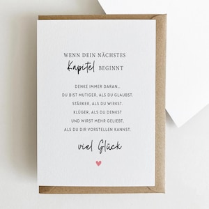 May include: A greeting card with a white interior and a brown envelope. The card features black text, including "WENN DEIN N&Auml;CHSTES Kapitel BEGINNT" and other motivational phrases. A small pink heart is at the bottom.