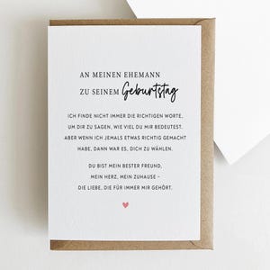 May include: A greeting card with a white interior and a brown envelope. The card has German text, including "An meinen Ehemann zu seinem Geburtstag," and a heart symbol. The card is designed for a birthday.