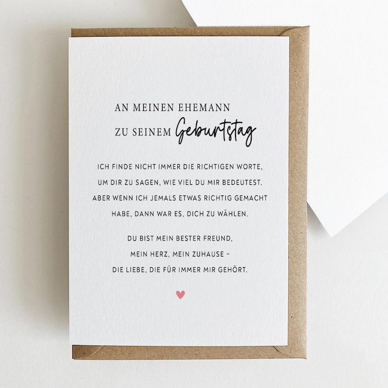 May include: A greeting card with a white interior and a brown envelope. The card has German text, including "An meinen Ehemann zu seinem Geburtstag," and a heart symbol. The card is designed for a birthday.