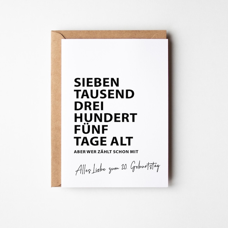 K&ouml;nnte beinhalten: Eine wei&szlig;e Gru&szlig;karte mit schwarzem Text: "SIEBEN TAUSEND DREI HUNDERT F&Uuml;NF TAGE ALT" und "Alles Liebe zum 20. Geburtstag" auf einem braunen Umschlag. Die Karte ist f&uuml;r den 20. Geburtstag.