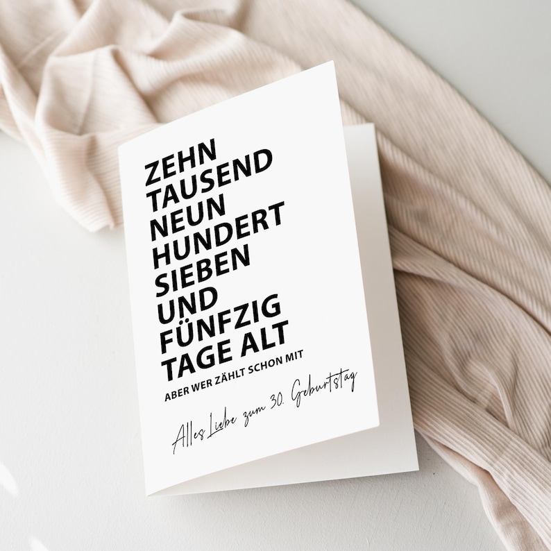 K&ouml;nnte beinhalten: Eine wei&szlig;e Gru&szlig;karte mit schwarzem Text. Der Text lautet "ZEHN TAUSEND NEUN HUNDERT SIEBEN UND F&Uuml;NFZIG TAGE ALT" und "Alles Liebe zum 30. Geburtstag". Die Karte ist ge&ouml;ffnet und zeigt das Innere.
