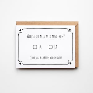 Könnte beinhalten: Eine Grußkarte in einem braunen Umschlag. Auf der Karte steht der Text "WILLST DU MIT MIR AUSGEHEN?" in Schwarz, mit zwei "JA"-Kontrollkästchen. Der Text "(SIEHT AUS, ALS HÄTTEN WIR EIN DATE)" steht ebenfalls auf der Karte.