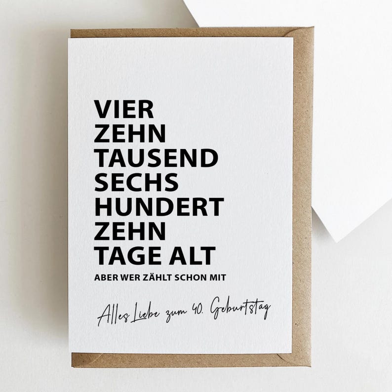 K&ouml;nnte beinhalten: Eine wei&szlig;e Gru&szlig;karte mit schwarzem Text in einem braunen Umschlag. Die Karte lautet "VIER ZEHN TAUSEND SECHS HUNDERT ZEHN TAGE ALT" und "Alles Liebe zum 40. Geburtstag".