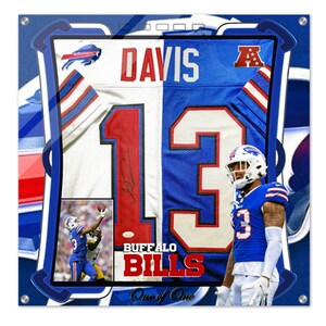 May include: A framed, signed Buffalo Bills jersey with the number 13 and the player's name "DAVIS" on the back. The jersey is split down the middle, with the left side being white and the right side being blue. The jersey is framed in a blue and white frame with the words "BUFFALO BILLS" and "One of One" at the bottom.