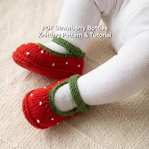 Può includere: Scarpine da neonato rosse a maglia con pois bianchi, che ricordano le fragole. Le scarpine hanno finiture verdi e sono indossate sui piedi di un bambino. Il testo "PDF Strawberry Botties Knitting Pattern & Tutorial" è visibile.