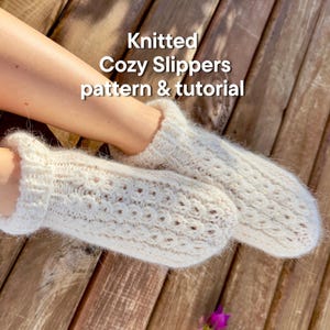 Può includere: Pantofole accoglienti lavorate a maglia color crema con un motivo strutturato. Le pantofole sono realizzate in filato morbido e hanno una consistenza soffice. L'immagine include il testo "Knitted Cozy Slippers pattern & tutorial".