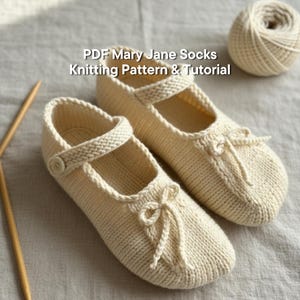 May include: A pair of cream-coloured knitted Mary Jane socks with a strap and button fastening. The socks feature a bow detail on the toe. The image includes the text "PDF Mary Jane Socks Knitting Pattern & Tutorial".
