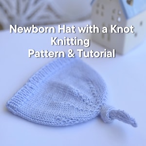 May include: A light blue knitted baby hat with a knot on top. The hat is on a white surface. Newborn Hat with a Knot Knitting Pattern & Tutorial.