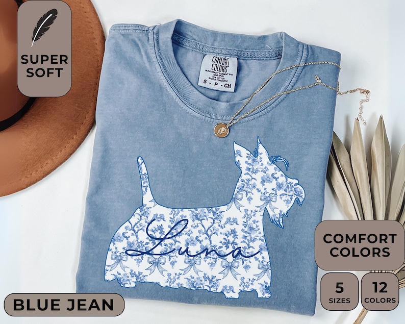 Pu&ograve; includere: T-shirt blu jeans Comfort Colors con un disegno floreale di cane e il nome "Luna". La maglietta ha un girocollo e maniche corte. &Egrave; presente anche il testo "Super Soft", "Comfort Colors", "5 Taglie" e "12 Colori".