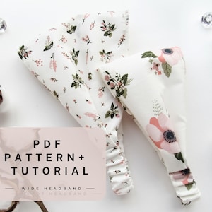 May include: A white headband with a floral pattern in shades of pink and green. The headband is made of fabric and has a gathered edge. The text "PDF PATTERN + TUTORIAL - WIDE HEADBAND -" is printed on a pink background.