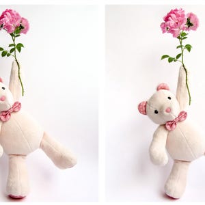 Two views of a cute handmade plush bear holding a stem of pink roses. This memory bear pattern and teddy bear pattern is perfect for those looking for a bear sewing pattern or a bunny sewing pattern. This plush sewing pattern is available as plushie patterns pdf and serves as an excellent memory bear template. Create a cute animal pattern project with this easy sewing pattern, which is ideal for a DIY memorial gift.