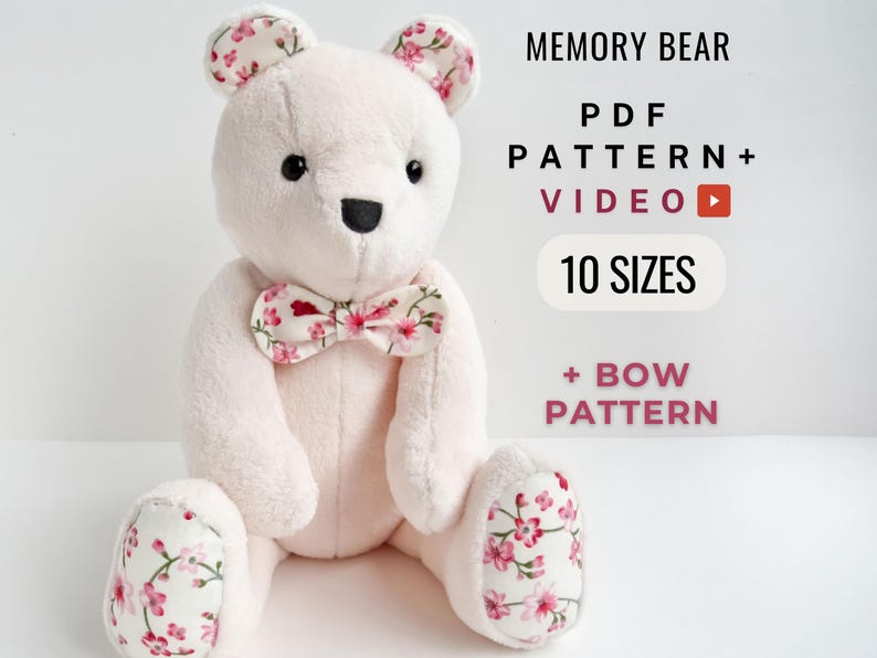 May include: A white plush teddy bear with pink floral fabric ears, paws, and a bow tie. The bear is sitting on a white background. The text "MEMORY BEAR PDF PATTERN + VIDEO 10 SIZES + BOW PATTERN" is displayed above the bear.