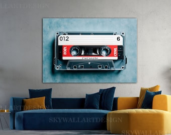 May include: A rectangular wall art print featuring a detailed illustration of a vintage audio cassette tape. The cassette is primarily black with a prominent red center label, white text reading 012 and 6, and the word CaCasete printed below.