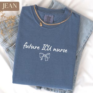 May include: A blue jean t-shirt with the text "future ICU nurse" and a white bow graphic.